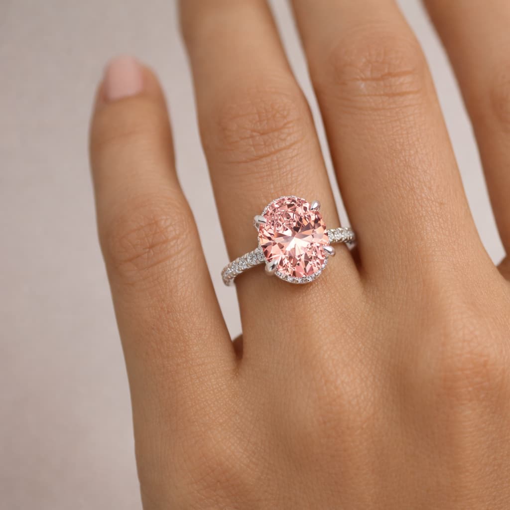 14K white gold oval pink diamond engagement ring with pavé band worn on woman's hand luxury jewelry gift