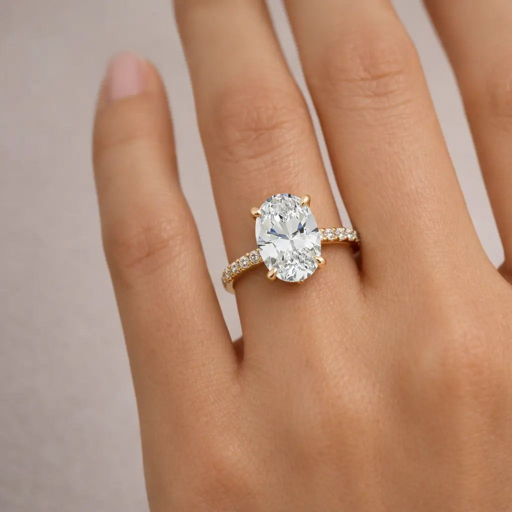 14k yellow gold oval diamond engagement ring with pavé band worn on woman's hand luxury jewelry gift