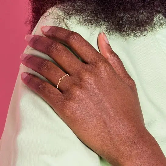 14K rose gold polished open heart ring worn on hand showing the petite heart design and slim band