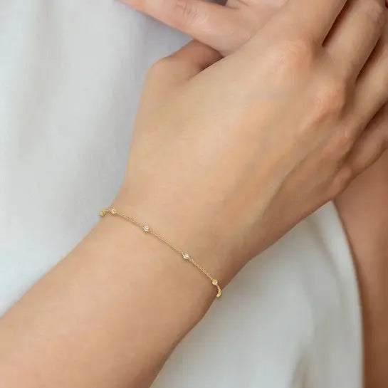 14K yellow gold 1/6 carat lab grown diamond station bracelet worn on wrist showing delicate scale