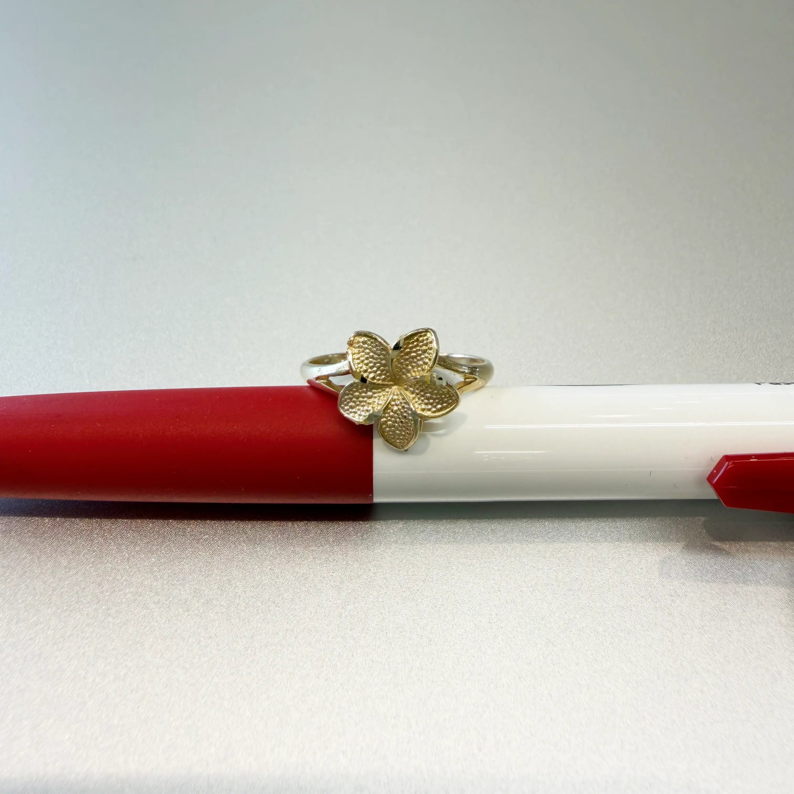 14K yellow gold plumeria flower ring medium size with beaded petal texture and split shank band on white background