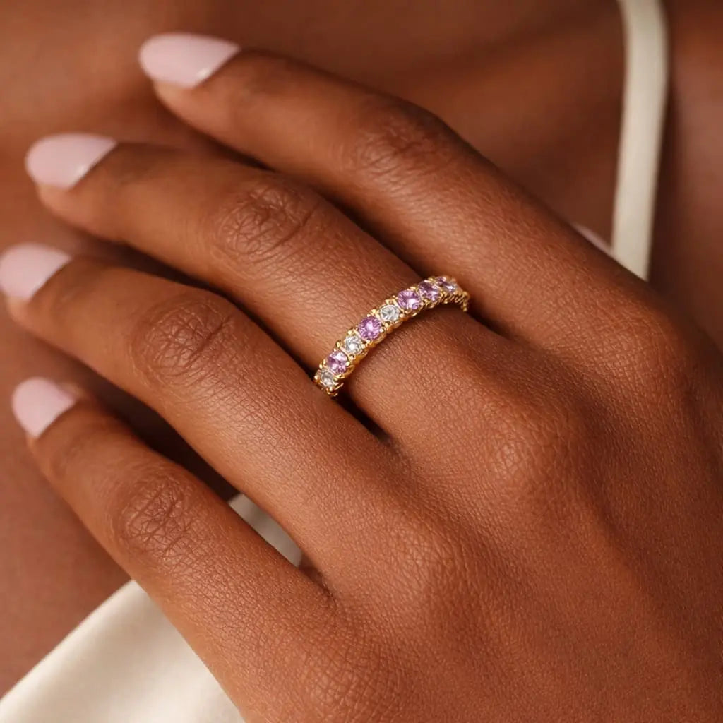 woman with darker skin wearing 14k yellow gold eternity ring with lab grown diamonds and pink sapphires elegant stacking ring gift jewelry