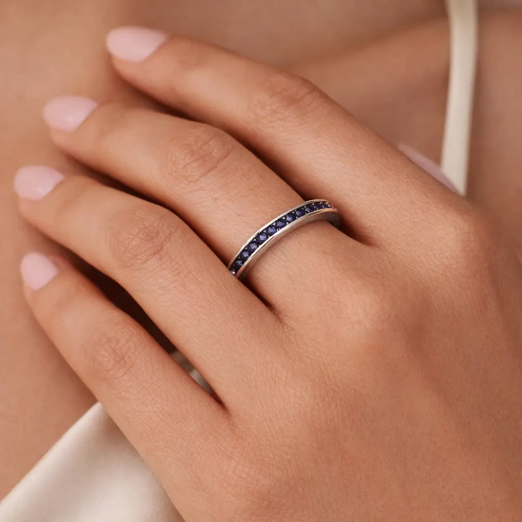 woman wearing 14k white gold blue sapphire channel wedding band elegant stacking ring everyday jewelry gift